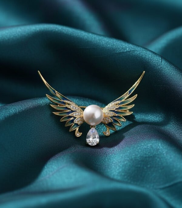 Soar with elegance wearing this Angel Wing Brooch, featuring delicate enamel, a radiant pearl, and a teardrop stone for a heavenly touch